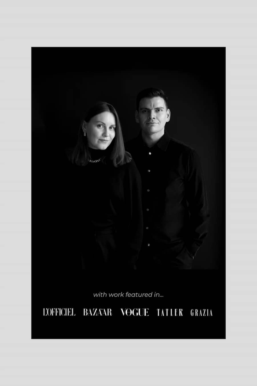 A black-and-white fashion editorial-style portrait print featuring a man and a woman in dark clothing against a black background, with small white text at the bottom reading 'with work featured in.