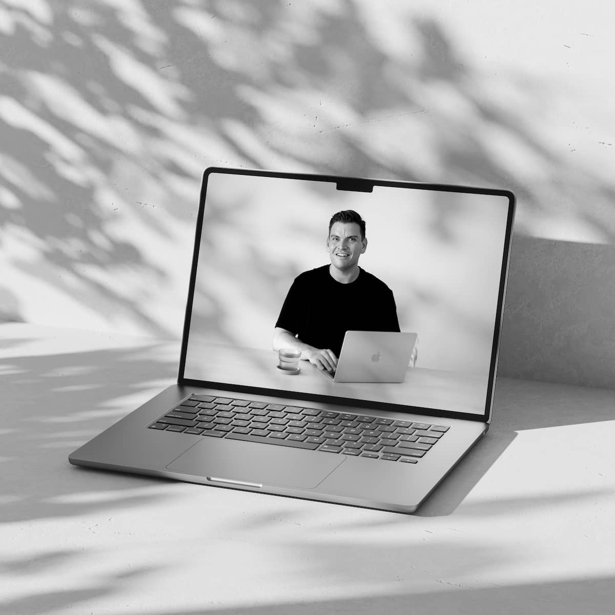 A laptop mockup showing a screen shot of a video course, image is black and white.