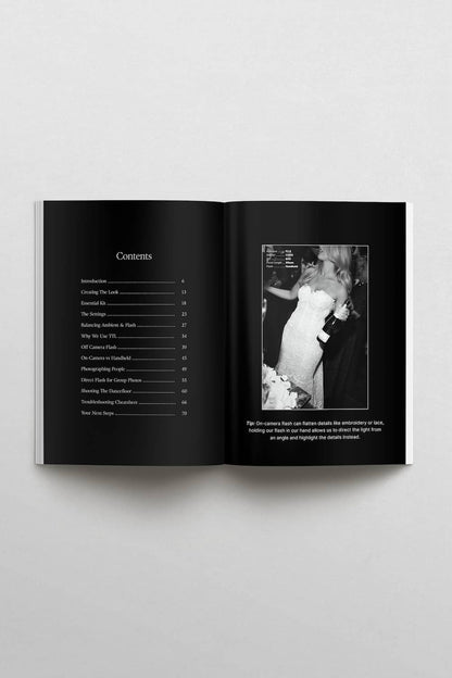 An open black book or magazine spread on a light gray background, showing a table of contents on the left page and a black-and-white inset photograph with caption text on the right page.
